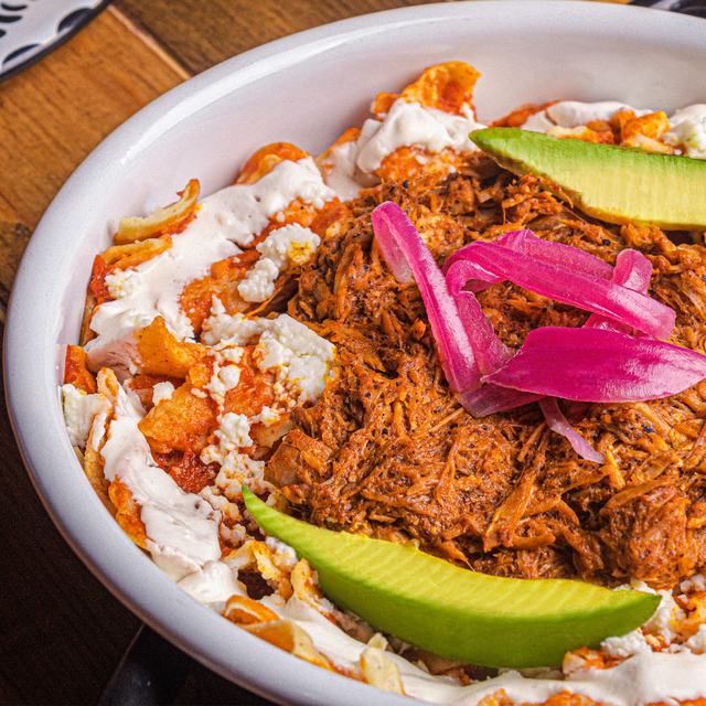 Chilaquiles con cochinita pibil y cebolla morada
